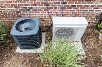 A central AC unit and Mini Split unit outside of a home or business